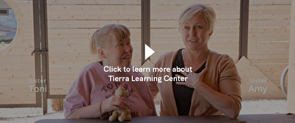 Two sisters sitting next to each other talking about Tierra fundraising efforts.